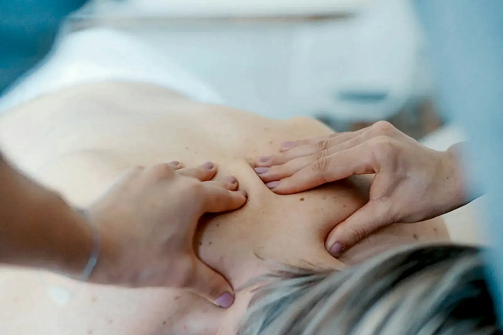 person massaging the back of a woman